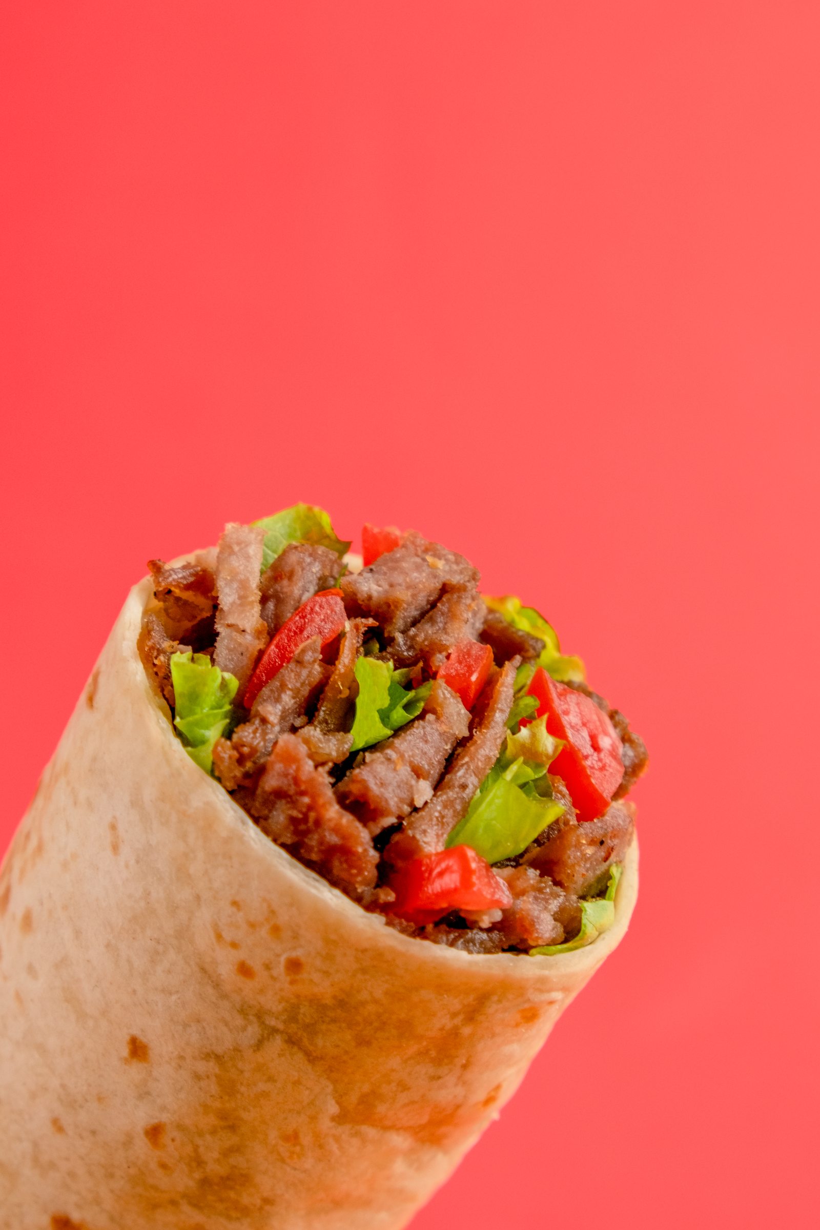 Doner kebab wrap on red background